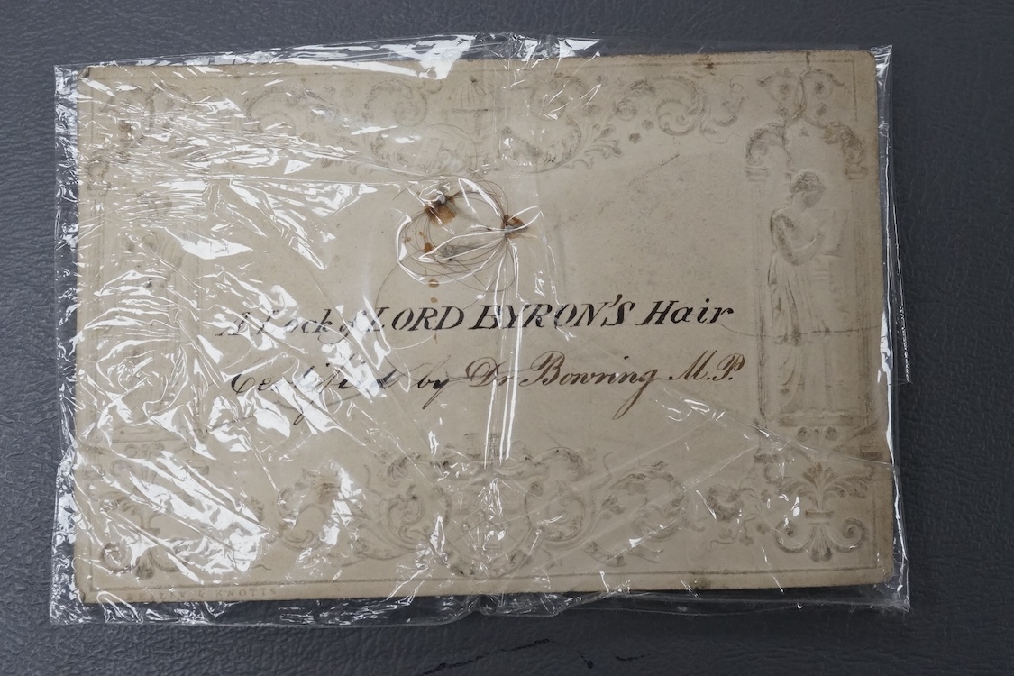 A lock of Lord Byron's hair mounted on an early 19th century embossed card decorated with classical figures, 11.3 x 7.5cm, stamped ‘Beilby & Knotts’, with a contemporary handwritten description stating; ‘A Lock of Lord B